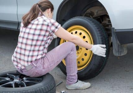 college girl changing tire