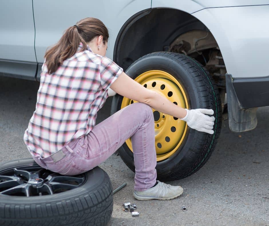 college girl changing tire